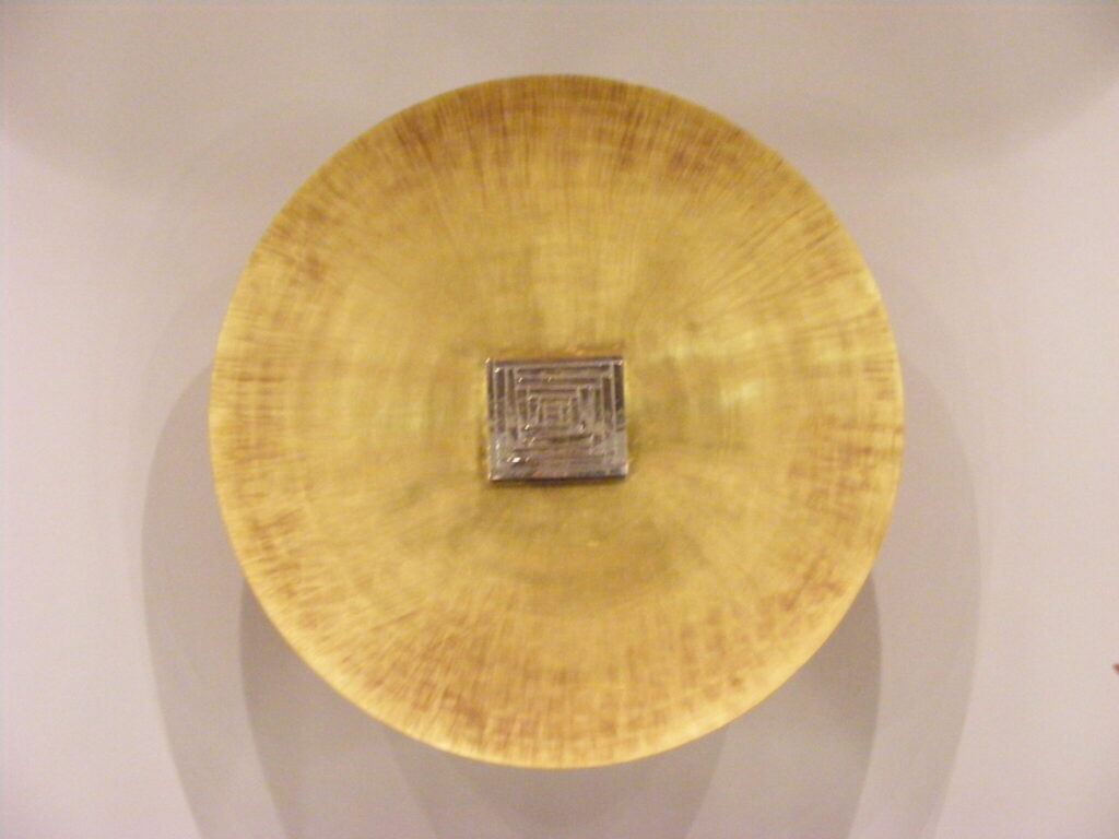 Eine gelbe Schale aus Glas liegt auf dem Boden