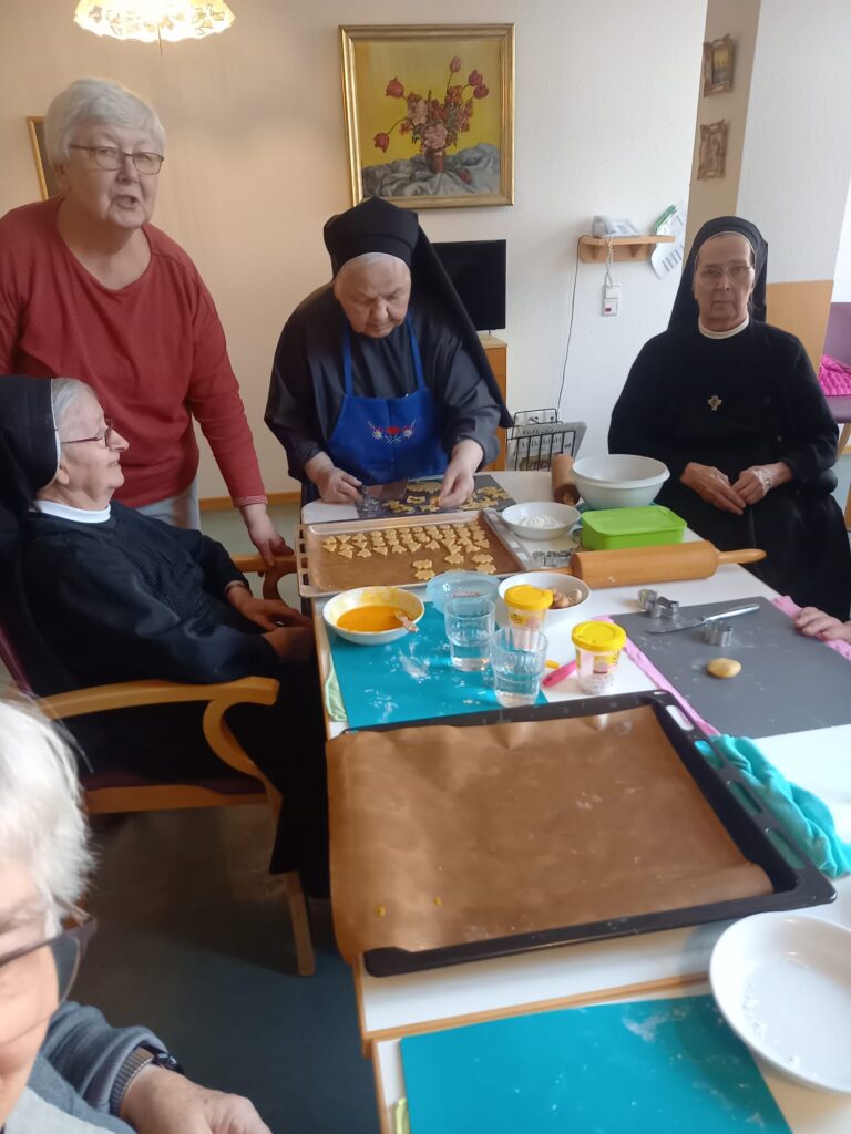 Auf dem Bild sieht man drei Schwestern beim backen von Plätzchen.